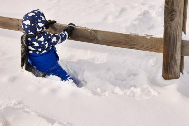 Karda tek başına küçük bir çocuk uzaklara bakar.
