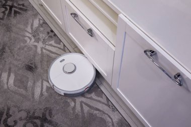 Robot elektrikli süpürge otomatik halı temizliği yapıyor.