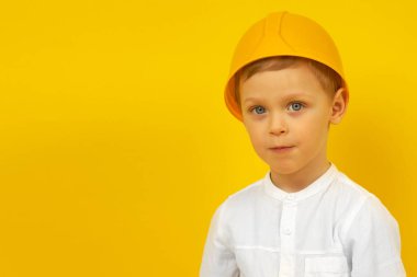 Siyah şapkalı, beyaz gömlekli, mavi gözlü şirin bir çocuk.