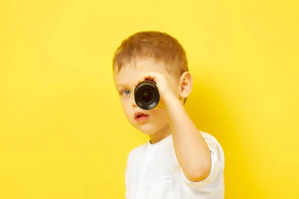 Щаслива дитина дивиться через телескоп на жовтому тлі — стокове фото