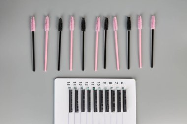 Siyah arka planda takma kirpikleri ve fırçaları olan bir tablet..