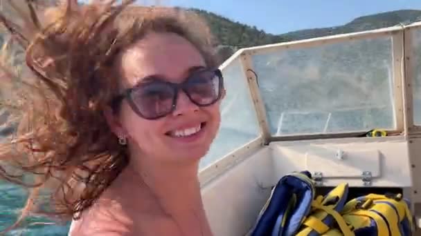 かわいい女の子は笑顔とスピードボートで波を駆け抜ける — ストック動画