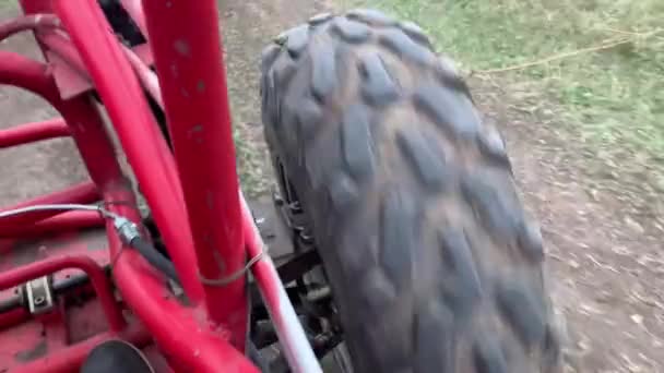 View of the red buggy wheel while driving on a dirt road — Stock Video