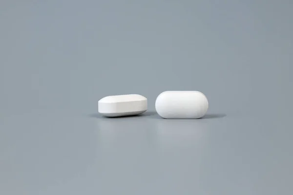 Two pills on a gray background. — Stock Photo, Image