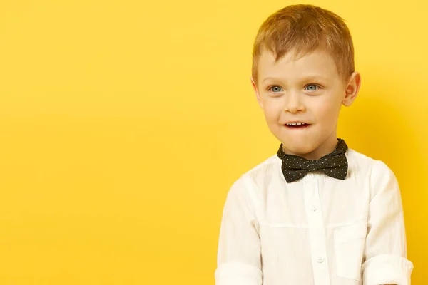 El niño mira pensativamente a la distancia en un backgro amarillo — Foto de Stock