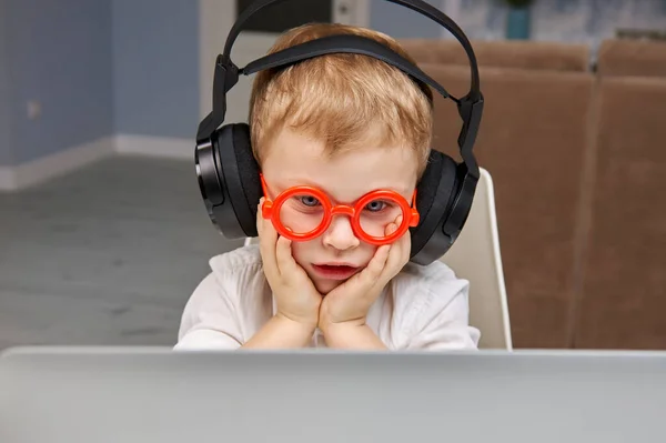 Το αγόρι με τα γυαλιά είναι σοκαρισμένο και έκπληκτο από αυτό που είδε στο διαδίκτυο από ένα λάπτοπ. — Φωτογραφία Αρχείου