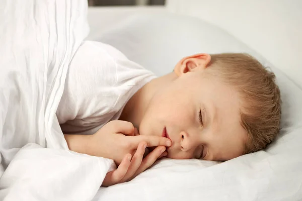Bebek beyaz bir karyolada tatlı tatlı uyuyor.. — Stok fotoğraf