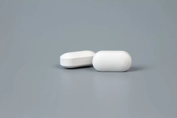 Two pills on a gray background. — Stock Photo, Image