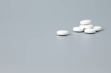 Gri arka planda beyaz haplar yığını