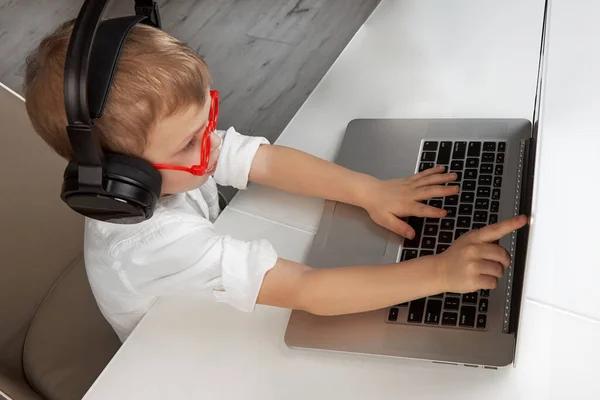 Ένα Αγόρι Ασύρματα Ακουστικά Και Κόκκινα Γυαλιά Χρησιμοποιεί Την Οθόνη — Φωτογραφία Αρχείου