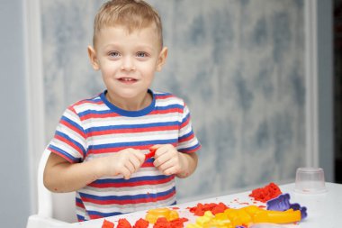 Bir çocuk güneşteki kinetik kumlarda oynar