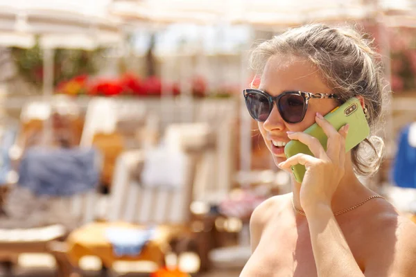 Een Jonge Vrouw Een Groen Badpak Zonnebril Praat Een Mobiele — Stockfoto