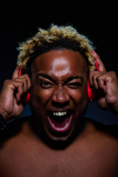 Afro-americano chico con auriculares mirando a la cámara y riendo — Foto de Stock