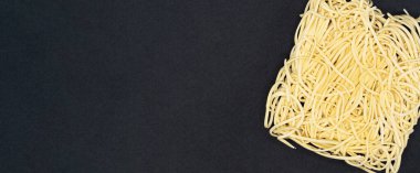 Siyah arka planda anlık erişteler. Fast food, abur cubur, abur cubur. Metnin için boş bir boşlukla kapat