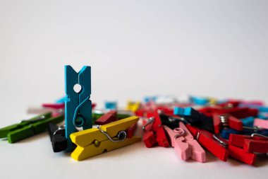 Makro mercekli, arka planı bulanık renkli minyatür klipslerden oluşan yığınlar. Mavi klip ayakta duran son klip gösterilir.