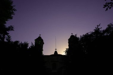Tepoztlan, Meksika 'daki bir Katolik kilisesinin telefon kayıtları. Fotoğraf, günbatımının altın saatinde açık bir gökyüzünün altında ana konuyu çerçeveleyen yeşillikleri gösteriyor..