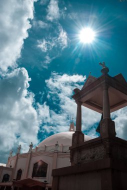 Güneşli ve bulutlu bir günde kilise. Katolik dindarlar bu yapıyı namaz kılmak ve ibadet etmek için toplarlar..
