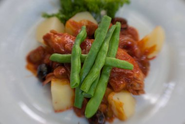 Patates ve yeşillikle kaplanmış çürümüş tavuk tabağı.