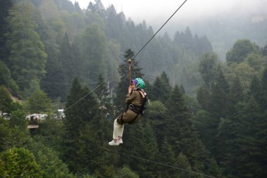 RIZE, TURKEY - 31 Ağustos 2018: Firtina Nehri üzerinde çelik halatla halatla kayma sporu yapan ve Camlihemsin, Rize, Türkiye 'de selfie çeken kadın.