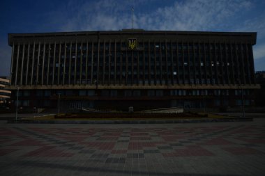 ZAPORIZHIA, UKRAINE - 24 Mart 2019: Zaporizhia bölge yönetim binası ve güzel güneşli bir günde Ukrayna bayrağı dalgaları