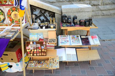 KYIV, UKRAINE - 5 Nisan 2019: Andriyivsky Descent 'teki insanlar ve hediyelik eşya dükkanları ve Kiev' deki St. Andrew Kilisesi manzarası. Kilise 1747-1754 yılları arasında mimar Bartolomeo Rastrelli tarafından inşa edilmiştir.