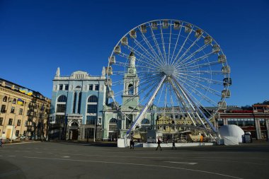 KYIV, UKRAINE - 5 Nisan 2019: Dönme dolap ve Kontraktova Meydanı 'ndaki St. Catherine eski Yunan manastırının kompleksi