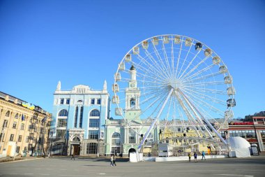 KYIV, UKRAINE - 5 Nisan 2019: Dönme dolap ve Kontraktova Meydanı 'ndaki St. Catherine eski Yunan manastırının kompleksi