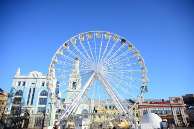 KYIV, UKRAINE - 5 Nisan 2019: Dönme dolap ve Kontraktova Meydanı 'ndaki St. Catherine eski Yunan manastırının kompleksi