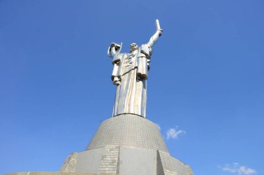 KYIV, UKRAINE - 10 Nisan 2019: Anavatanın tarihi müzedeki SSCB 'den bir kılıç ve bir tahta parçasıyla dikilmiş anıtı. Bulutlu gökyüzünün arka planında büyük bir heykel