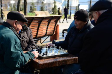KYIV, UKRAINE - 10 Nisan 2019: Bir grup erkek parkta satranç oynuyor ve Taras Shevchenko Ulusal Üniversitesi yakınlarındaki avluda hararetli bir tartışma yapıyorlar.