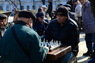 KYIV, UKRAINE - 10 Nisan 2019: Bir grup erkek parkta satranç oynuyor ve Taras Shevchenko Ulusal Üniversitesi yakınlarındaki avluda hararetli bir tartışma yapıyorlar.