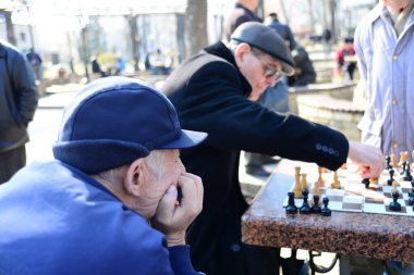 KYIV, UKRAINE - 10 Nisan 2019: Bir grup erkek parkta satranç oynuyor ve Taras Shevchenko Ulusal Üniversitesi yakınlarındaki avluda hararetli bir tartışma yapıyorlar.