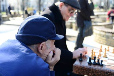 KYIV, UKRAINE - 10 Nisan 2019: Bir grup erkek parkta satranç oynuyor ve Taras Shevchenko Ulusal Üniversitesi yakınlarındaki avluda hararetli bir tartışma yapıyorlar.