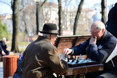 KYIV, UKRAINE - 10 Nisan 2019: Bir grup erkek parkta satranç oynuyor ve Taras Shevchenko Ulusal Üniversitesi yakınlarındaki avluda hararetli bir tartışma yapıyorlar.