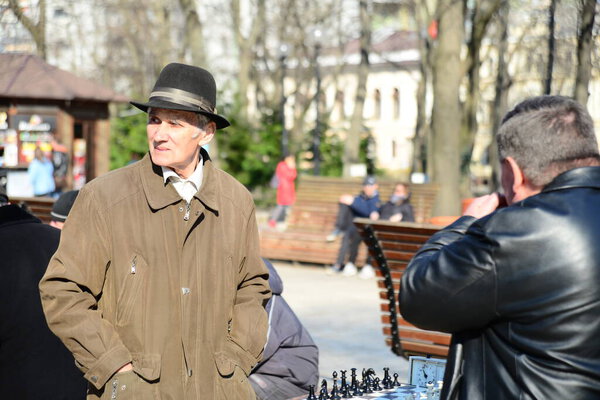 КИЕВ, УКРАИНА - 10 апреля 2019 года: Группа мужчин играет в шахматы в парке и горячо обсуждается во дворе Киевского национального университета имени Тараса Шевченко.
