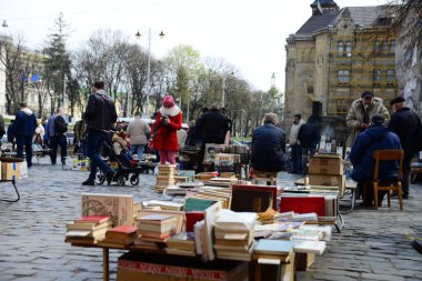 LVIV, UKRAINE - 17 Nisan 2019: Lviv Ukrayna 'daki anıt kitabı yazıcısı Ivan Fyodorov' da ikinci el kitap pazarı. Ivan Fyodorov 1574 yılında Lviv Ukrayna 'nın ilk kitabı Havari' de yayınlandı.