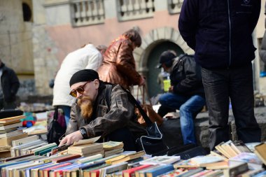 LVIV, UKRAINE - 17 Nisan 2019: Lviv Ukrayna 'daki anıt kitabı yazıcısı Ivan Fyodorov' da ikinci el kitap pazarı. Ivan Fyodorov 1574 yılında Lviv Ukrayna 'nın ilk kitabı Havari' de yayınlandı.