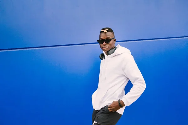 Joven Hombre Negro Africano Contra Una Pared Azul Mirando Cámara —  Fotos de Stock