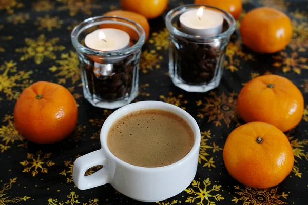 一杯咖啡 背景是黑色和金色的圣诞图案 玻璃杯中的曼达林和咖啡蜡烛 — 图库照片