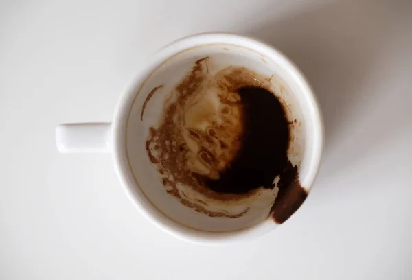 Coffee grounds in white cup on white background isolated. Top view