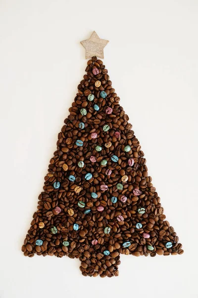 Різдвяна ялинка з кавових зерен з дерев'яною зіркою зверху на білому тлі ізольована — стокове фото