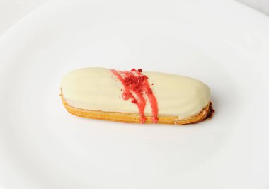 Vanilya kremalı ve beyaz tabakta çilek soslu Fransız tatlısı. Zarif servis biçimi