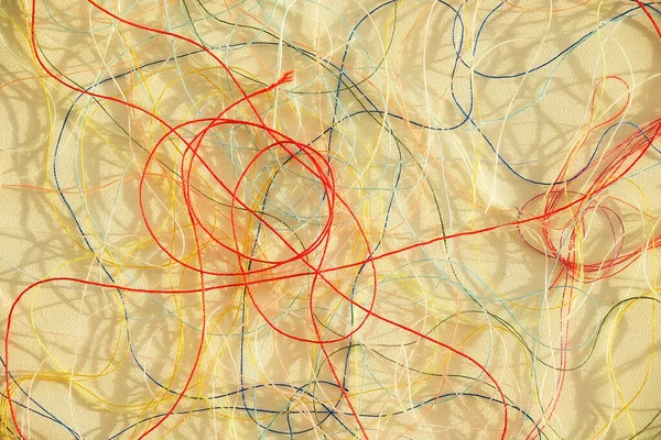 Colorful tangled threads on white surface. Abstract background
