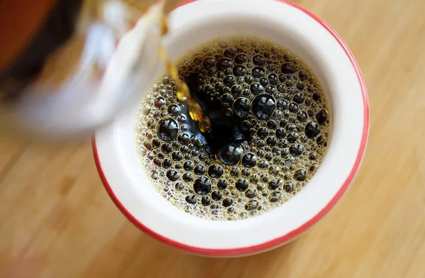 Verter el café negro recién hecho sobre el filtro en primer plano de la taza. — Foto de Stock