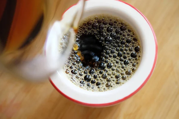 Verter el café negro recién hecho sobre el filtro en primer plano de la taza. — Foto de Stock