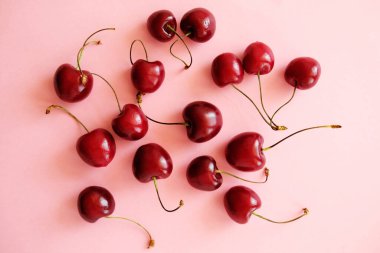 Kiraz serpme. Yumuşak pembe arka planda düz kiraz yatıyordu. Üst görünüm