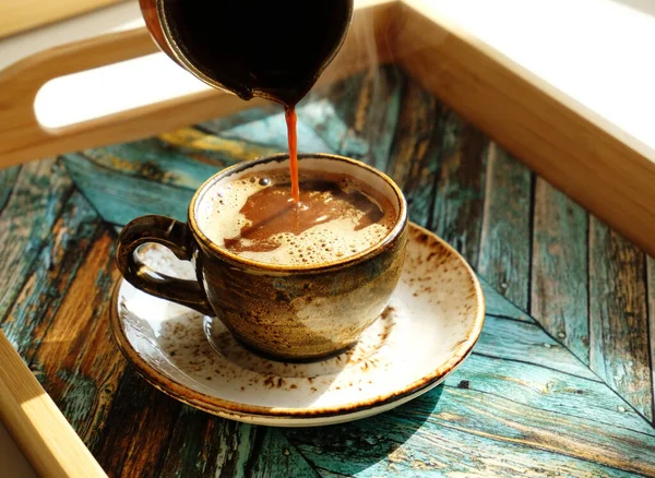 新鲜煮好的热土耳其咖啡倒入茶托上的陶瓷浓缩咖啡杯 绿松石木制托盘 — 图库照片