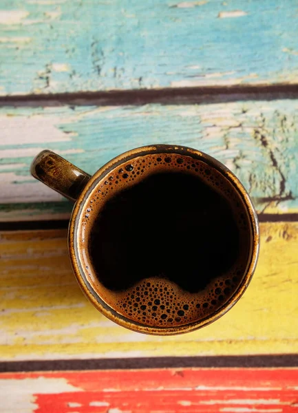 Café negro caliente fresco en taza de café expreso de cerámica. Vista superior, primer plano. Fondo de madera de color llano —  Fotos de Stock