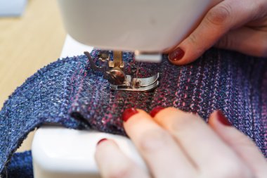 Kadınların elleri arkasında onun dikiş. Deri dikiş işlemine