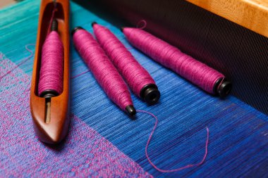 Biriktiricileri iplik ile mekikte mavi çözgü dokuma